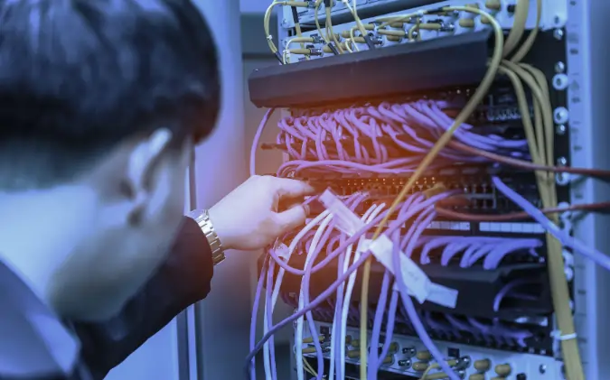 Bad ethernet cable causing network connectivity issues in a server rack while a technician inspects network cables